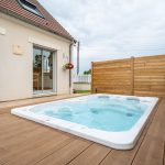 Spa spacieux installé sur une terrasse en bois - aménagement extérieur à Soissons