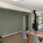 aménagement intérieur revêtement mur peinture couleur vert de gris salon table à manger parquet bois poêle à bois Sauveterre