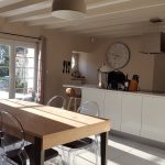 rénovation maison cuisine aménagée avec îlot central blanc laqué hotte salle à manger table bois carrelage grande dalle Veurey-Voroize