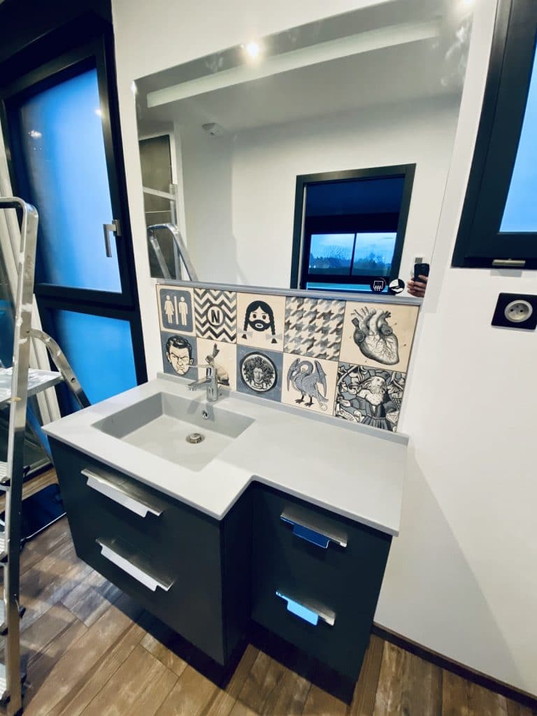 création d'une salle de bain à Saint-Omer : pose d'un meuble avec miroir, et carrelage moderne.