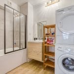 Rénovation d'un appartement à La Roche sur Yon : salle de bains avec baignoire, vasque et électroménager