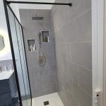 Zoom sur la douche rénovée avec niches murales intégrées pour produits de soin - rénovation de cette salle de bain à Elbeuf