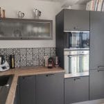 Meubles gris, plan de travail en bois, et crédance rétro - rénovation d'une cuisine à Saint-Genest-Malifaux près de Saint Etienne