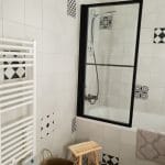 Zoom sur le pare baignoire, la baignoire et le sèche-serviettes - rénovation d'une salle de bain dans un appartement à Montpellier