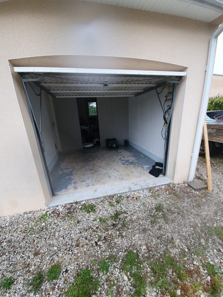Garage avant travaux, porte ouverte - Transformation d'un garage en bureau à Saint Saturnin