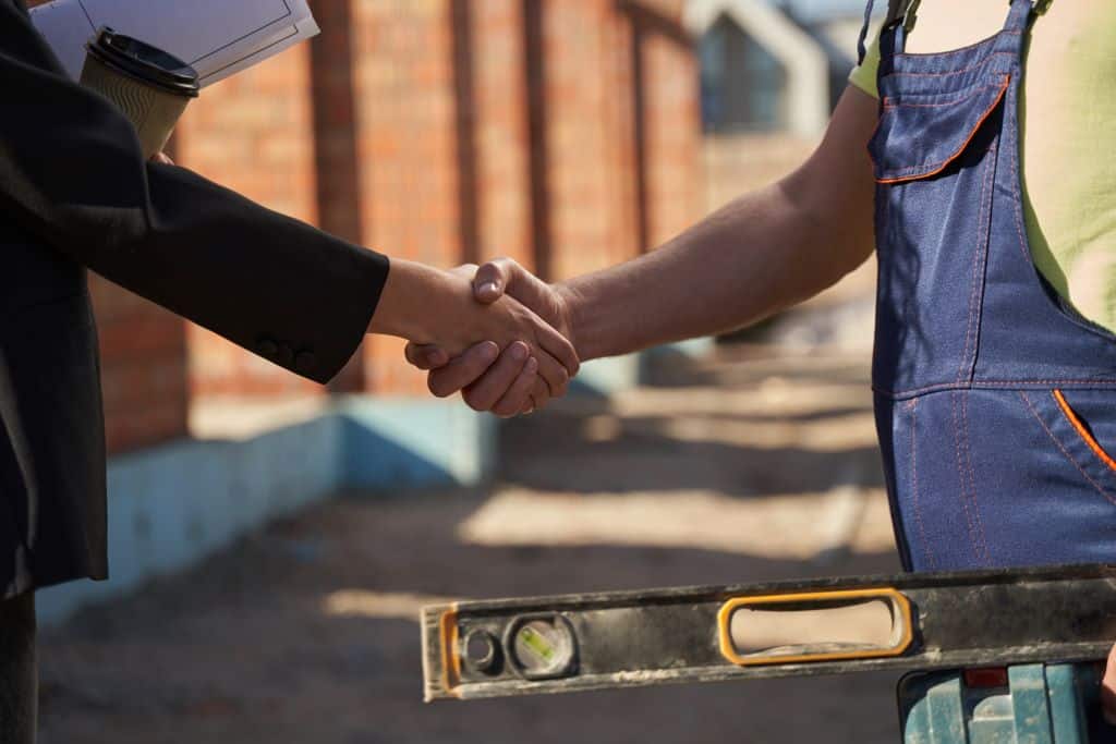 courtier travaux et artisans se serrent la main