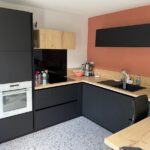 Rénovation d'une cuisine à Carquefou : aménagmeent avec meubles noirs et plan de travail en bois