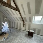 Rénovation d’une maison pour créer des biens locatifs à Allaire (56) - pièce mansardée avec poutre apparente